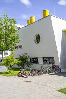 Deutschland, Bayern, München, Fahrräder geparkt vor moderner Vorschule im Theresienpark - MAMF01060