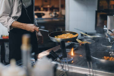 Chef cooking pasta in Italian restaurant kitchen - OCAF00440