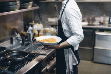 Chef cooking pasta in Italian restaurant kitchen - OCAF00441