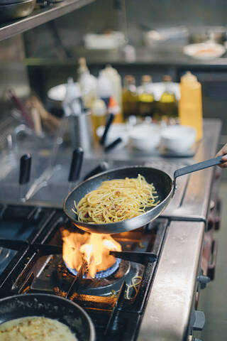 Chefkoch kocht Nudeln in der Küche eines italienischen Restaurants, lizenzfreies Stockfoto