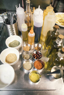 Nahaufnahme von Gewürzen und Ölflaschen in einer Restaurantküche - OCAF00447