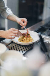 Chef preparing a dish in traditional Italian restaurant kitchen - OCAF00457