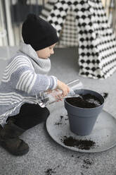 Junge bei der Gartenarbeit auf dem Balkon - JOHF05704