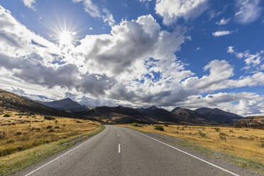 New Zealand, Bealey, Clouds over empty State Highway 73 with mountains in background - FOF11538