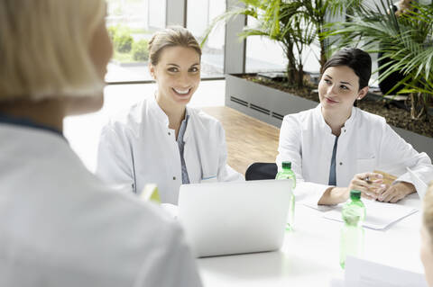 Porträt einer lächelnden Ärztin mit Laptop in einer Besprechung, lizenzfreies Stockfoto