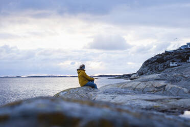 Woman on rocky coast - JOHF06024