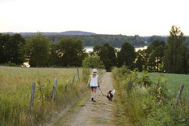 Mädchen geht mit Hund spazieren - JOHF06080