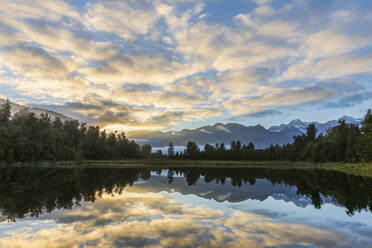 New Zealand, Westland District, Fox Glacier, Clouds reflecting in Lake Matheson at sunrise - FOF11570