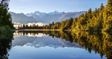 Neuseeland, Westland District, Fox Glacier, Lake Matheson mit Spiegelung des umgebenden Waldes und der entfernten Bergkette - FOF11572