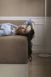 Porträt einer schönen jungen Frau, die zu Hause auf der Couch liegt - JPF00419
