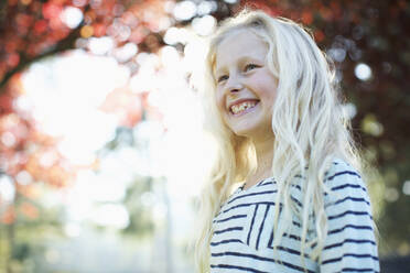 Confident, happy girl smiling in autumn park - FSIF04546
