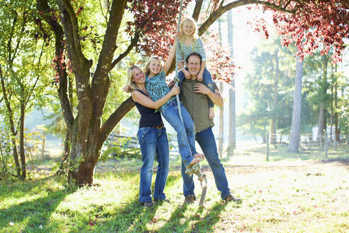 Porträt glückliche Familie auf Seilschaukel in sonnigen Herbst Park - FSIF04547