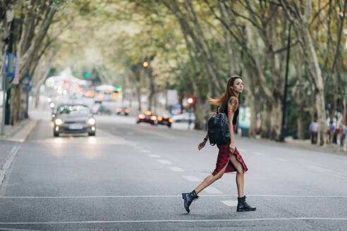 Junge Frau beim Überqueren der Stadtstraße - FSIF04605