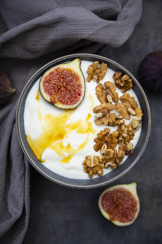 Schale mit griechischem Joghurt mit Honig, Walnüssen und Feigenscheiben, lizenzfreies Stockfoto