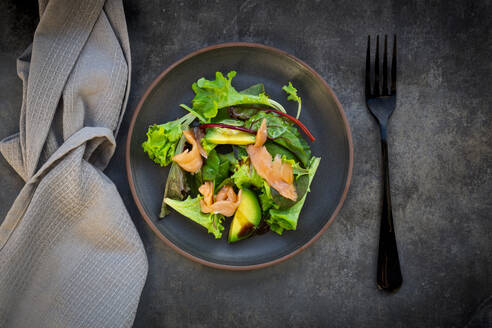 Teller mit grünem Salat mit Feldsalat, Rucola, Spinat, rotem Blattsalat, Rote-Bete-Blättern, Avocado, Lachsfleisch und Balsamico-Essig - LVF08565