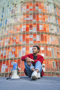 Porträt eines reifen Mannes mit Megaphon im Freien sitzend, Barcelona, Spanien - AFVF05225