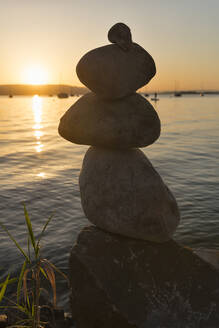 Germany, Baden-Wurttemberg, Allensbach, Cairn standing on shore of Lake Constance at sunset - SHF02217