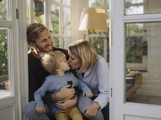 Happy and affectionate family in sunroom at home - KNSF07046