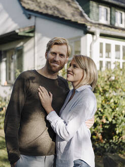 Porträt eines lächelnden Paares vor seinem Haus - KNSF07049