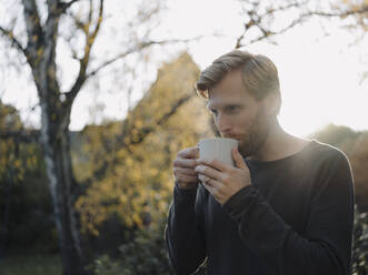 Mann bei einer Kaffeepause im Garten - KNSF07061