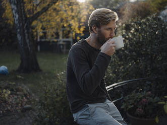 Mann bei einer Kaffeepause im Garten - KNSF07062