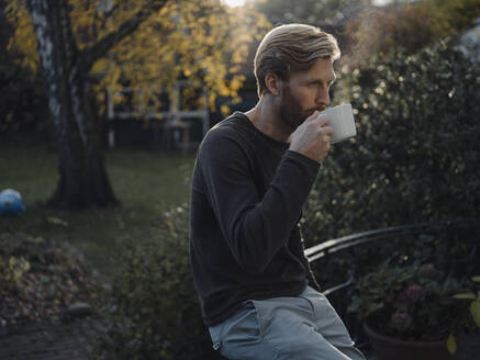 Man having a coffee break in garden - KNSF07062