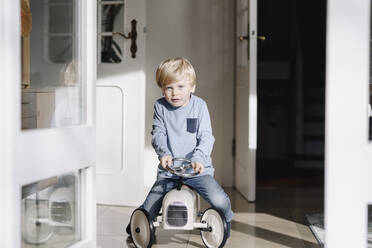 Porträt eines Jungen, der zu Hause mit einem Spielzeugauto spielt - KNSF07067