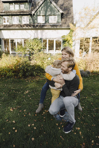 Glückliche, liebevolle Familie im Garten, lizenzfreies Stockfoto