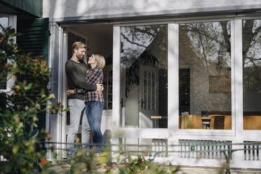 Couple embracing on terrace of their home - KNSF07119