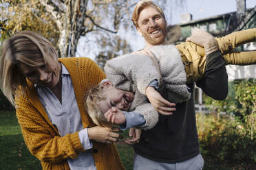 Happy family having fun in garden - KNSF07134