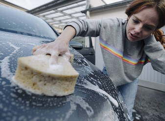 Rothaarige Frau reinigt ihr Auto - KNSF07148