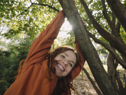 Glückliche rothaarige Frau genießt den Herbst in einem Park - KNSF07154