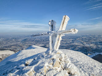 Italien, Schneebedecktes Kreuz auf dem Gipfel des Monte Acuto - LOMF00978