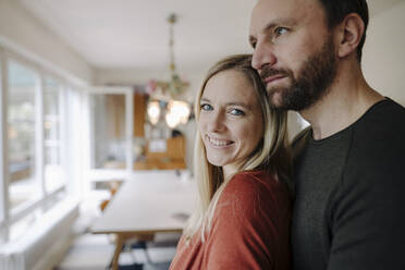 Happy couple embracing in their comfortable home - KNSF07197