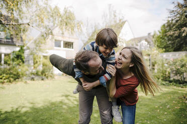Parents and son having fun, playing in the garden - KNSF07239