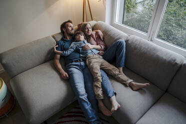 Glückliche Familie entspannt auf der Couch - KNSF07273