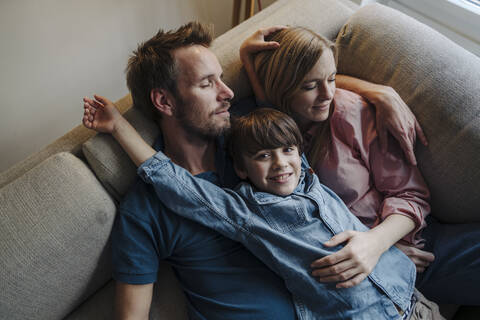 Happy family relaxing on couch stock photo