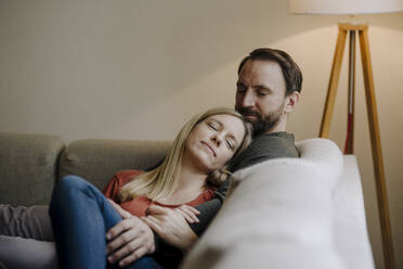 Ehepaar sitzt zu Hause auf der Couch und entspannt sich - KNSF07291