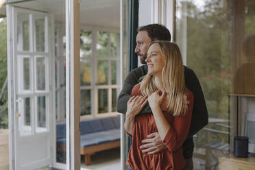 Happy couple embracing in their comfortable home - KNSF07306