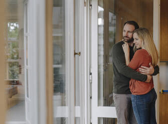 Ein glückliches Paar umarmt sich in seinem gemütlichen Haus - KNSF07308