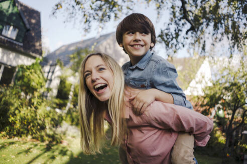 Mutter und Sohn haben Spaß, spielen im Garten - KNSF07340