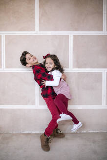 Boy lifting up girl at a wall - GRCF00106