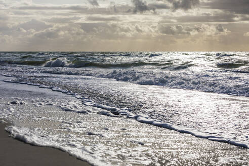 Deutschland, Mecklenburg-Vorpommern, Prerow, Wellen streichen über den Sandstrand der Ostsee in der Abenddämmerung - WDF05668