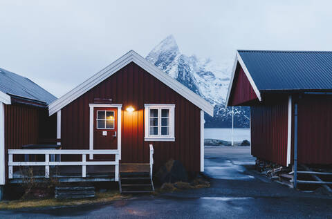 Beleuchtete rote Hütte an der Küste, Hamnoy, Lofoten, Norwegen, lizenzfreies Stockfoto