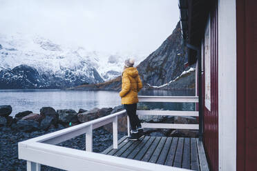 Tourist genießt die Aussicht in Hamnoy, Lofoten, Norwegen - DGOF00072