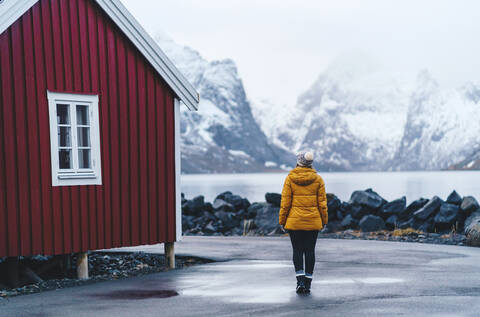 Tourist bei der Erkundung des Fischerdorfs Hamnoy, Lofoten, Norwegen, lizenzfreies Stockfoto