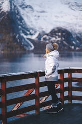 Tourist genießt die Aussicht in Hamnoy, Lofoten, Norwegen - DGOF00078