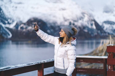 Happy tourist taking a selfie at Hamnoy, Lofoten, Norway - DGOF00079