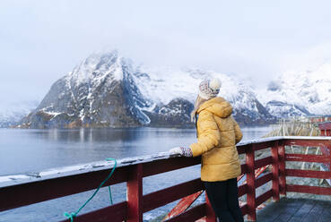 Tourist genießt die Aussicht in Hamnoy, Lofoten, Norwegen - DGOF00085