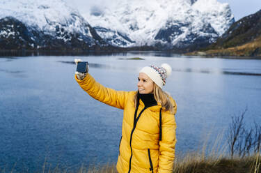 Tourist macht ein Selfie in Hamnoy, Lofoten, Norwegen - DGOF00098